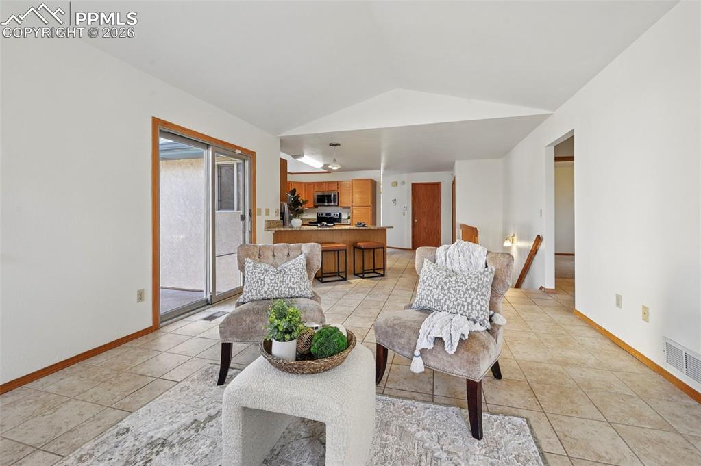 Image 21 of 42: Bright family room with brick gas fireplace, slider walk-out to concrete pa