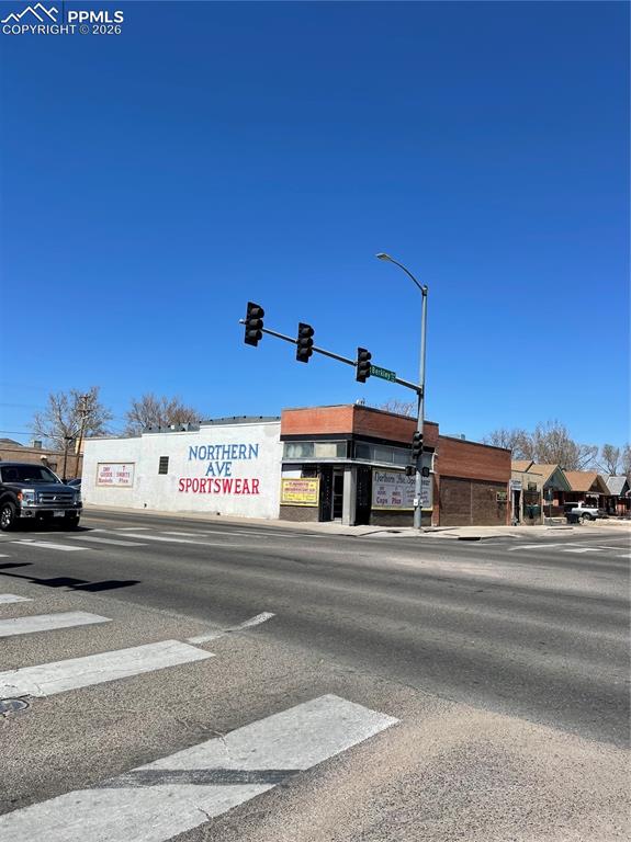 Caption: View of asphalt road with traffic lights, sidewalks, street lighting, and curbs