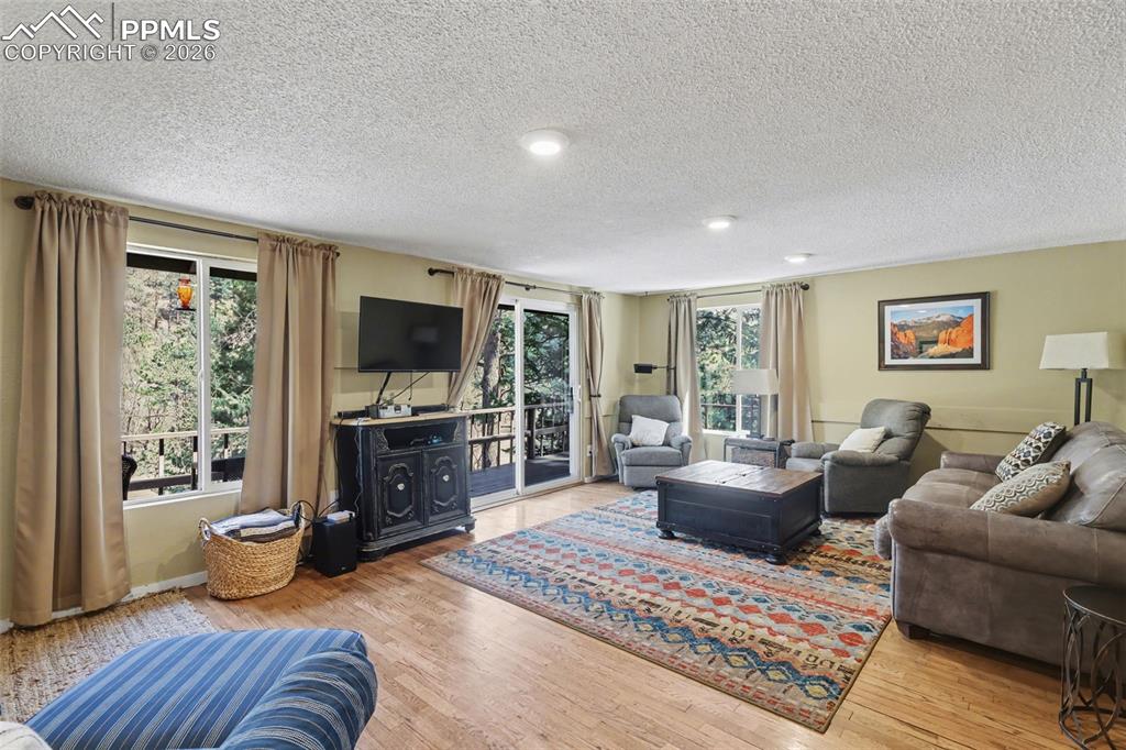Image 16 of 33: Living area with  hardwood flooring, and a lot of natural lighting