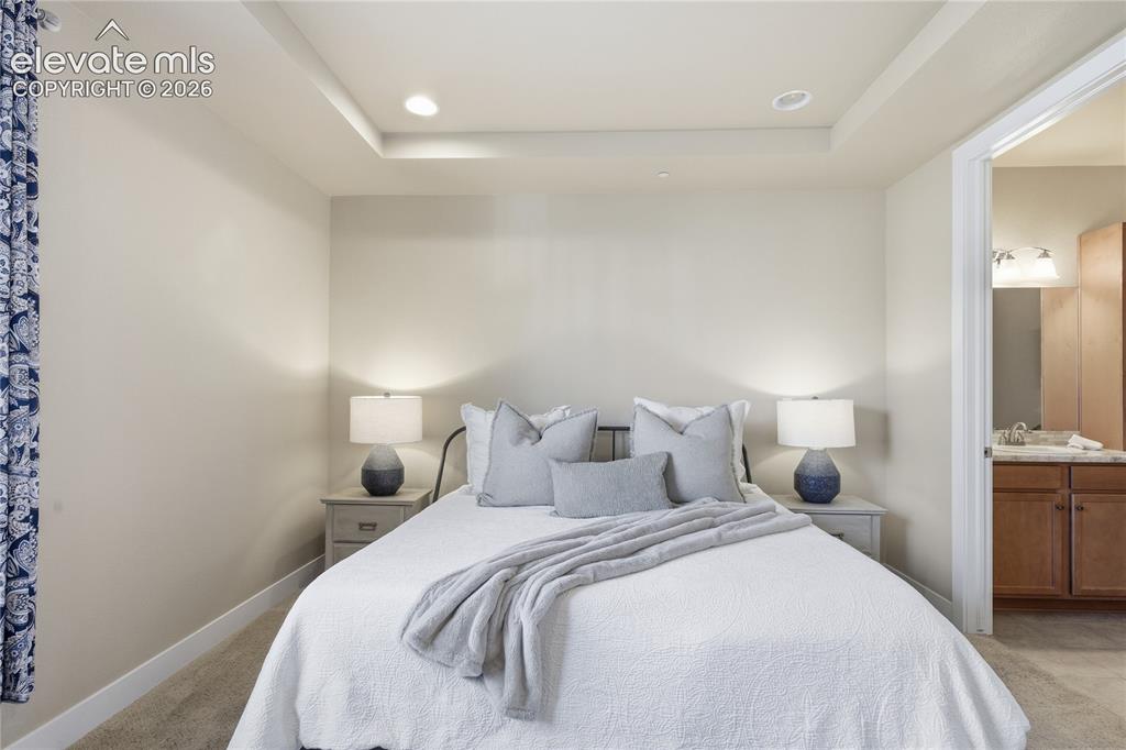 Image 14 of 28: Recessed lighting in a tray ceiling, carpeted flooring, and a doorway to a