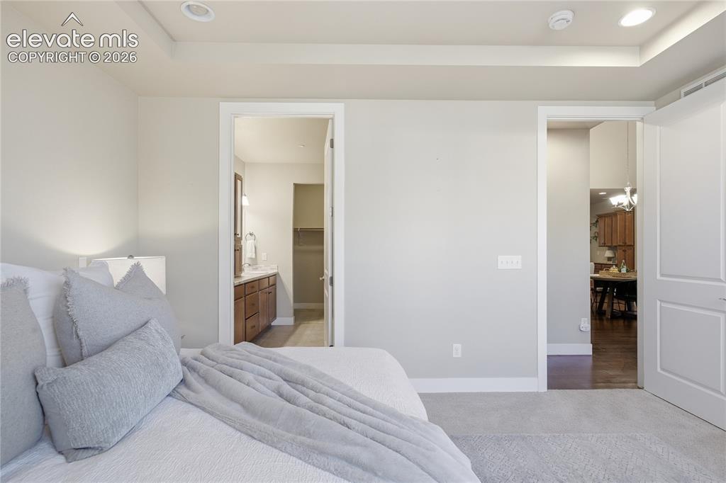 Image 15 of 28: Recessed lighting, tray ceiling detail, wood-finish flooring, white trim, a