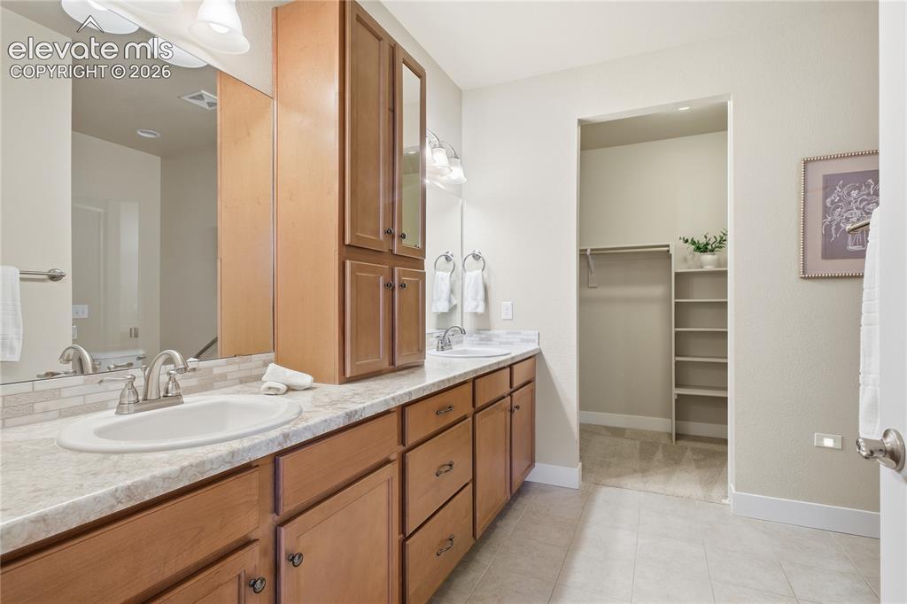 Image 17 of 28: Spa-inspired primary bathroom featuring a long vanity with wood cabinetry,