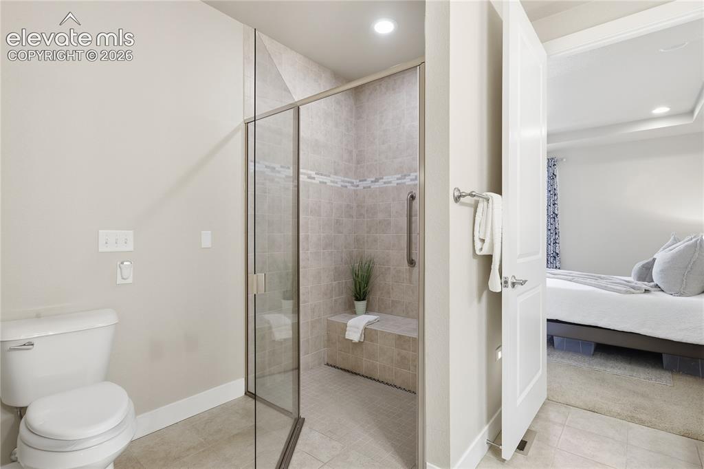 Image 18 of 28: Bathroom featuring a glass-enclosed walk-in shower with a built-in bench, t