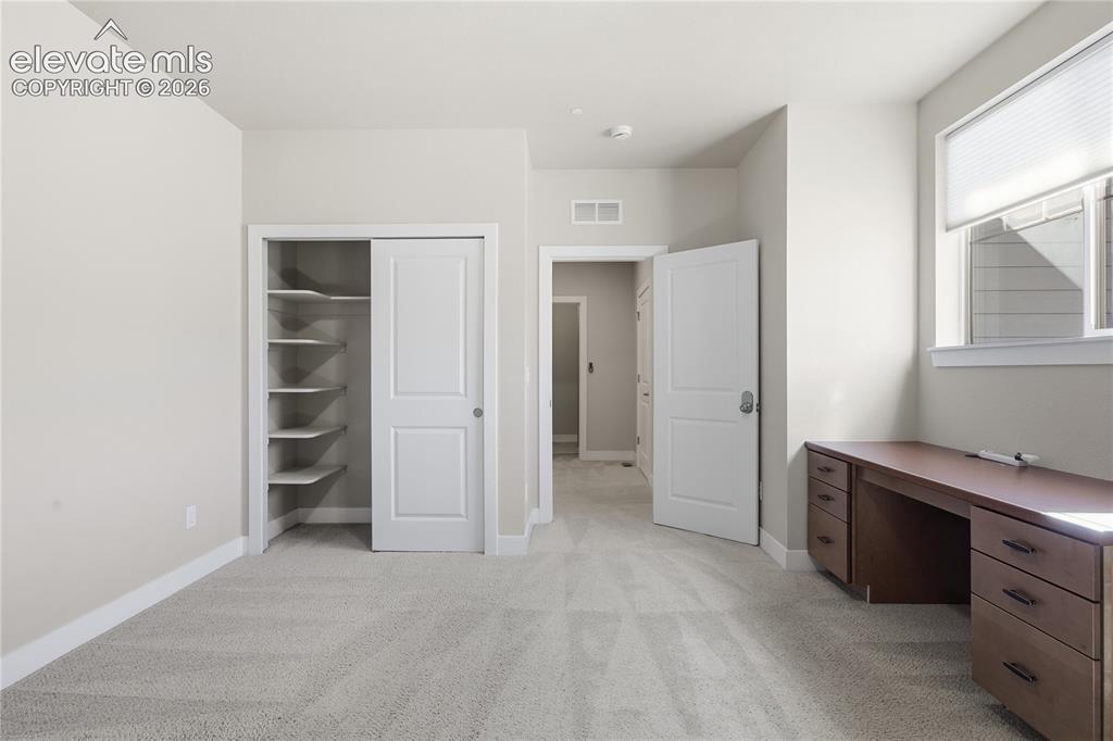 Image 22 of 28: Plush carpeting, window with blinds, bi-fold closet doors, built-in closet