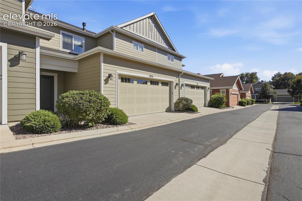 Image 28 of 28: Siding exterior with multiple attached garages, well-maintained landscaping