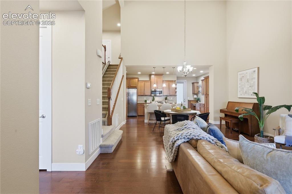 Image 3 of 28: Vaulted ceiling above living area, wood-finish flooring, open-concept kitch