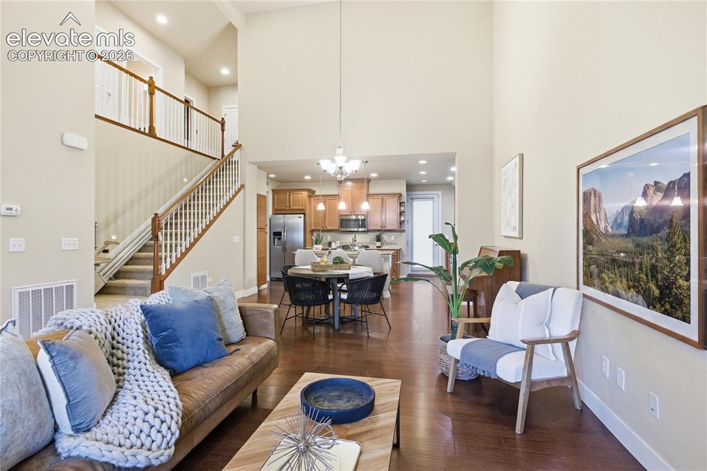Image 4 of 28: Vaulted ceilings, wood-finish flooring, a kitchen with wood cabinetry, a di