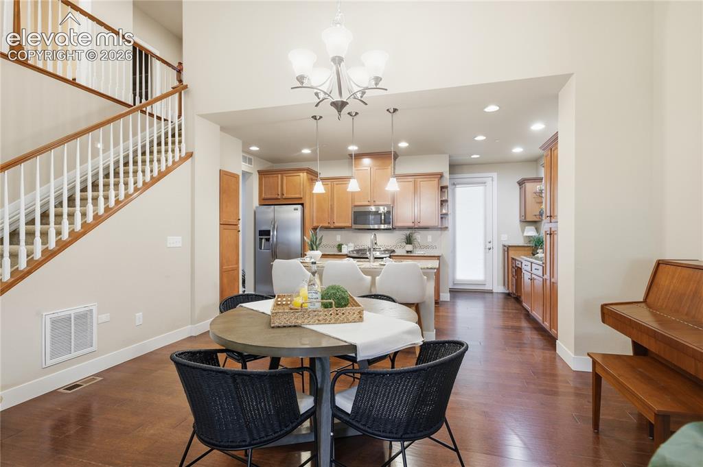 Image 5 of 28: Wood-finish flooring throughout, with a wood staircase featuring white balu