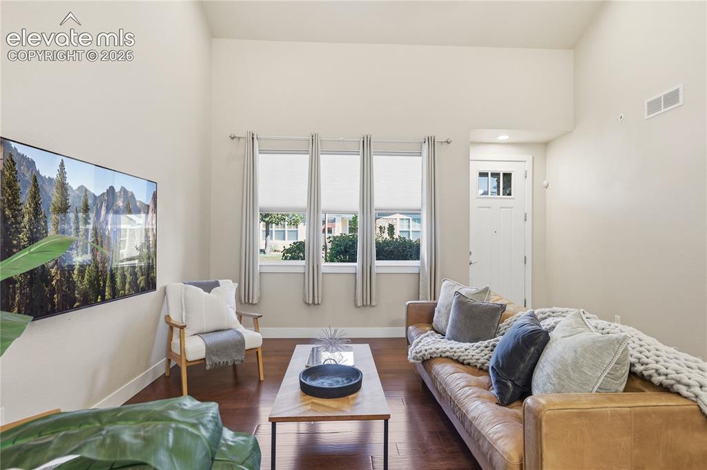Image 6 of 28: Bright, light-filled living space featuring hardwood flooring, floor-to-cei