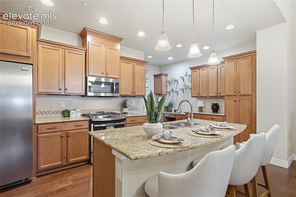 Image 8 of 28: Kitchen featuring wood-finish flooring, stainless steel appliances, light w