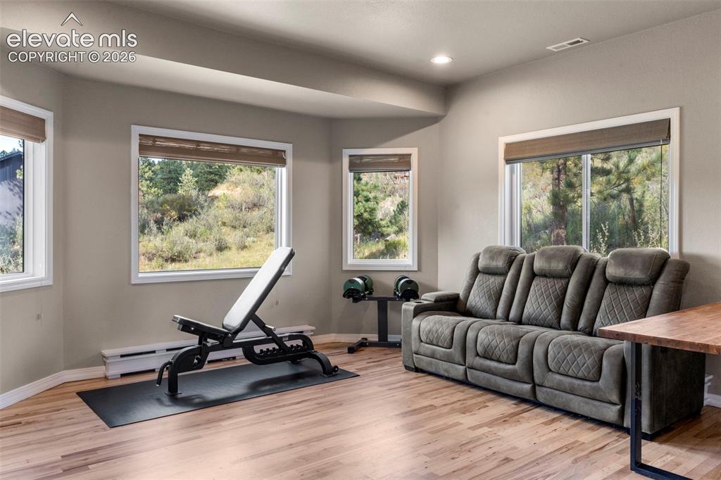 Image 14 of 46: Workout room featuring light wood-type flooring, recessed lighting, and bas
