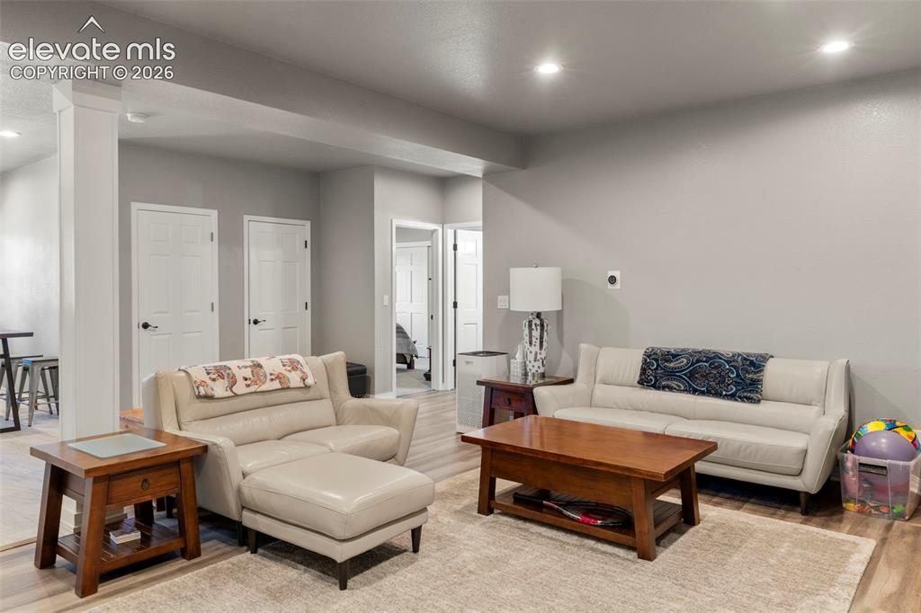 Image 28 of 46: Living area with recessed lighting and light wood-style floors