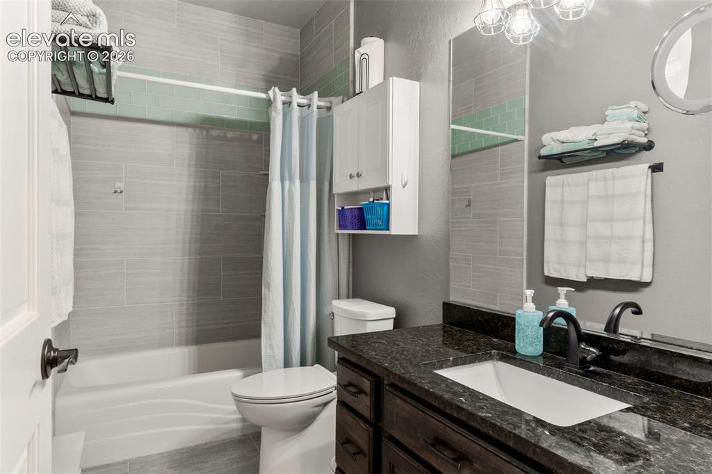 Image 32 of 46: Full bathroom featuring shower / bathtub combination with curtain, a textur