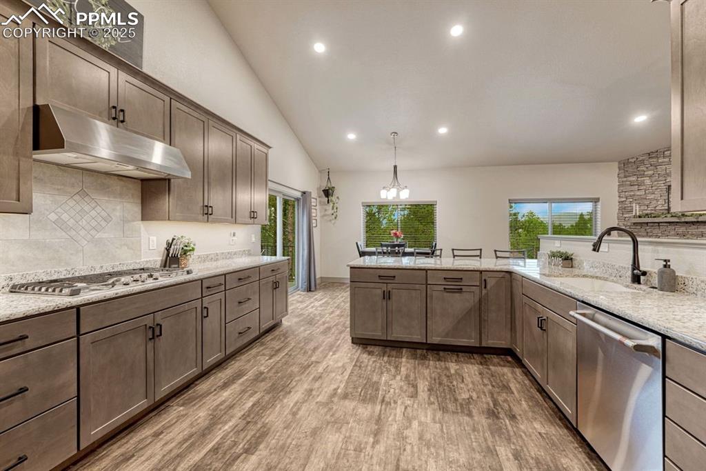 Image 13 of 32: The home’s warm tones are carried into the kitchen with maple cabinetry and