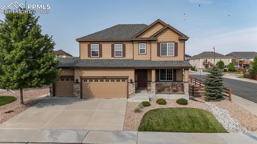 Caption: Craftsman-style home featuring covered porch, concrete driveway, stone siding, a garage, and a shing
