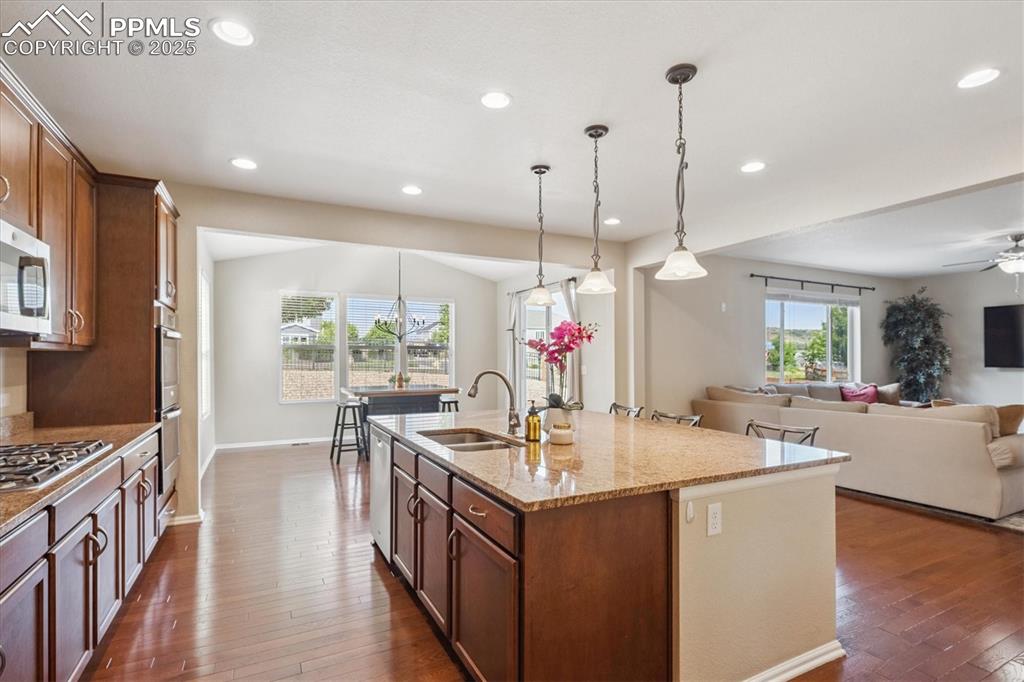Image 10 of 36: Kitchen featuring dark wood-style floors, light stone countertops, decorati