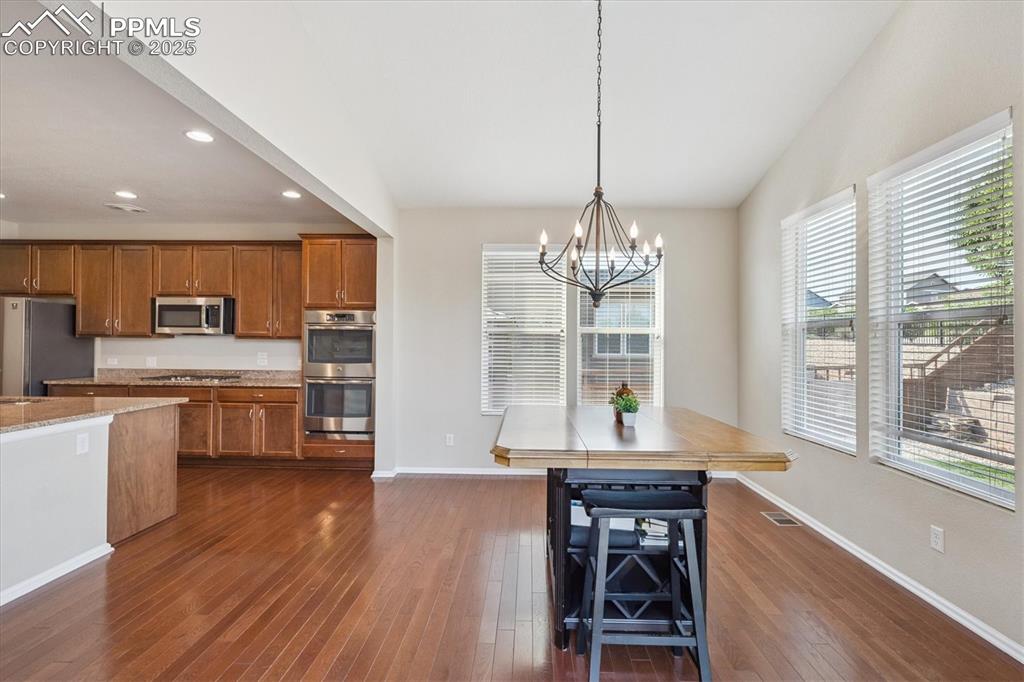 Image 11 of 36: Kitchen featuring brown cabinets, recessed lighting, stainless steel applia