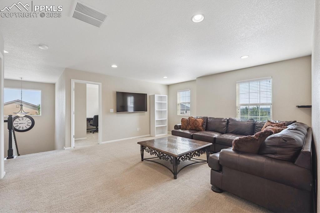 Image 15 of 36: Carpeted loft with a textured ceiling, recessed lighting, and a desk