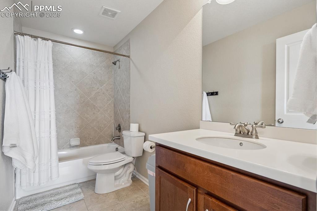 Image 24 of 36: Bathroom featuring vanity, shower / bath combination with curtain, and tile