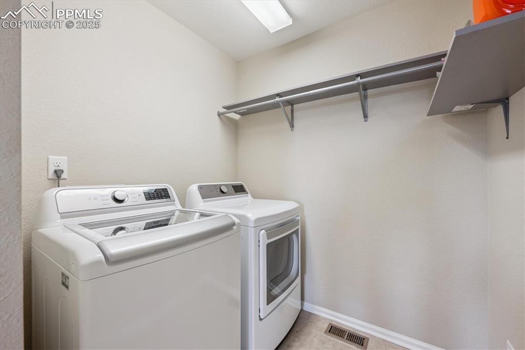 Image 25 of 36: Upper Laundry area with washing machine and dryer and baseboards