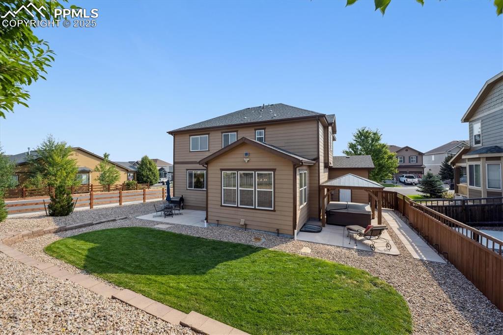 Image 30 of 36: Back of house with a patio, a gazebo, and a fenced backyard