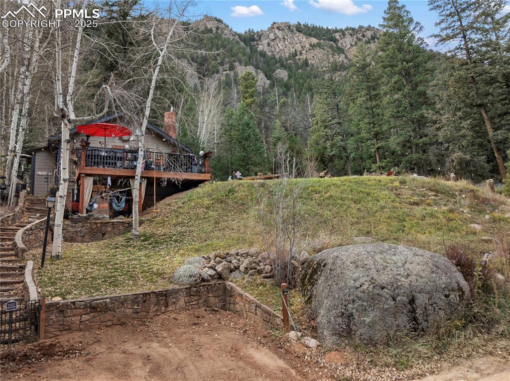Image 3 of 47: View of yard featuring a view of trees, a deck with mountain view, and stai