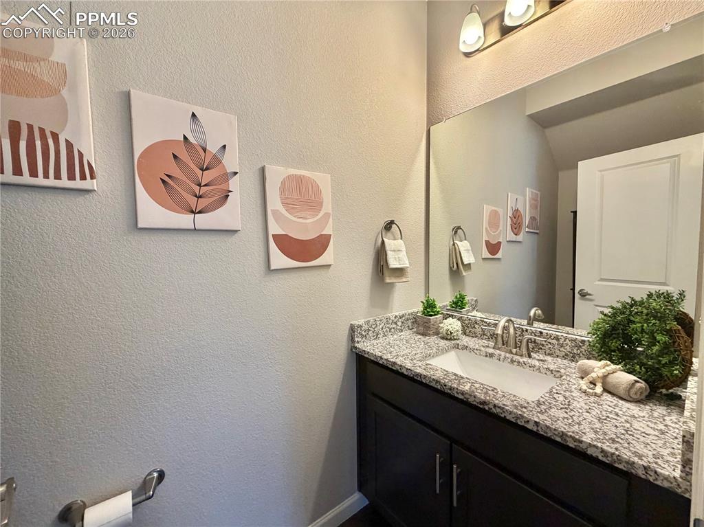 Image 21 of 41: Bathroom with vanity and a textured wall