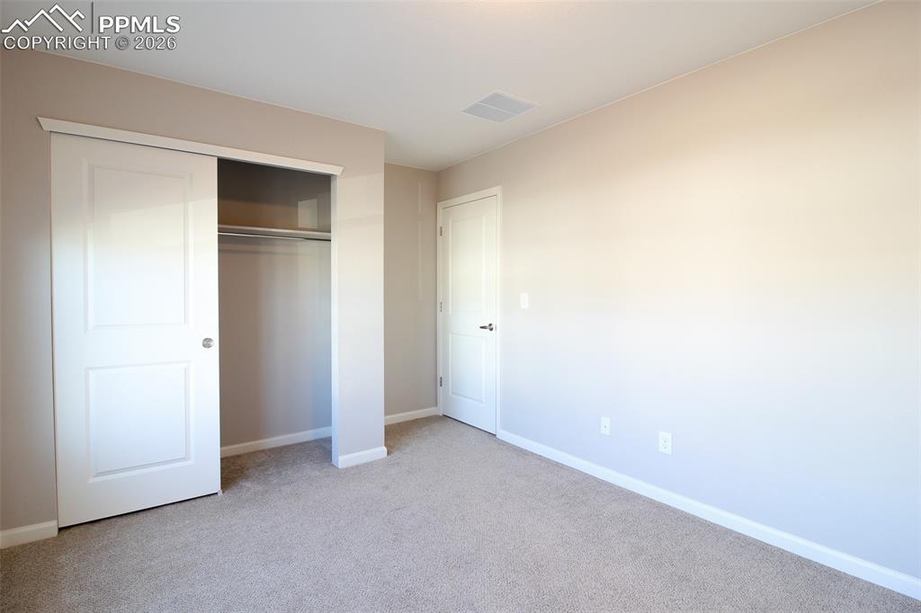 Image 24 of 41: Unfurnished bedroom with light carpet and a closet