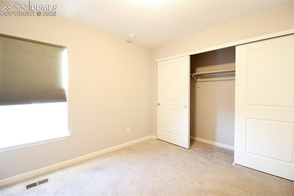 Image 25 of 41: Unfurnished bedroom with light carpet and a closet