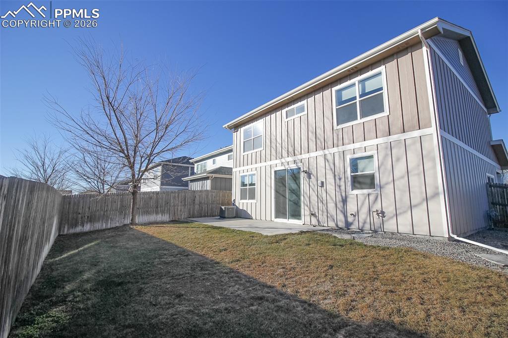 Image 27 of 41: Rear view of property with a patio area, board and batten siding, and a fen
