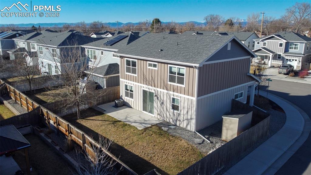 Image 28 of 41: Back of house with a fenced backyard, a residential view, a shingled roof, 