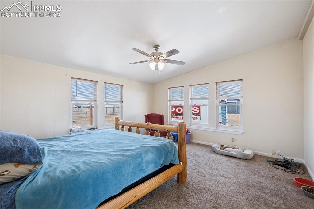 Image 44 of 45: Carpeted bedroom featuring baseboards, multiple windows, and lofted ceiling