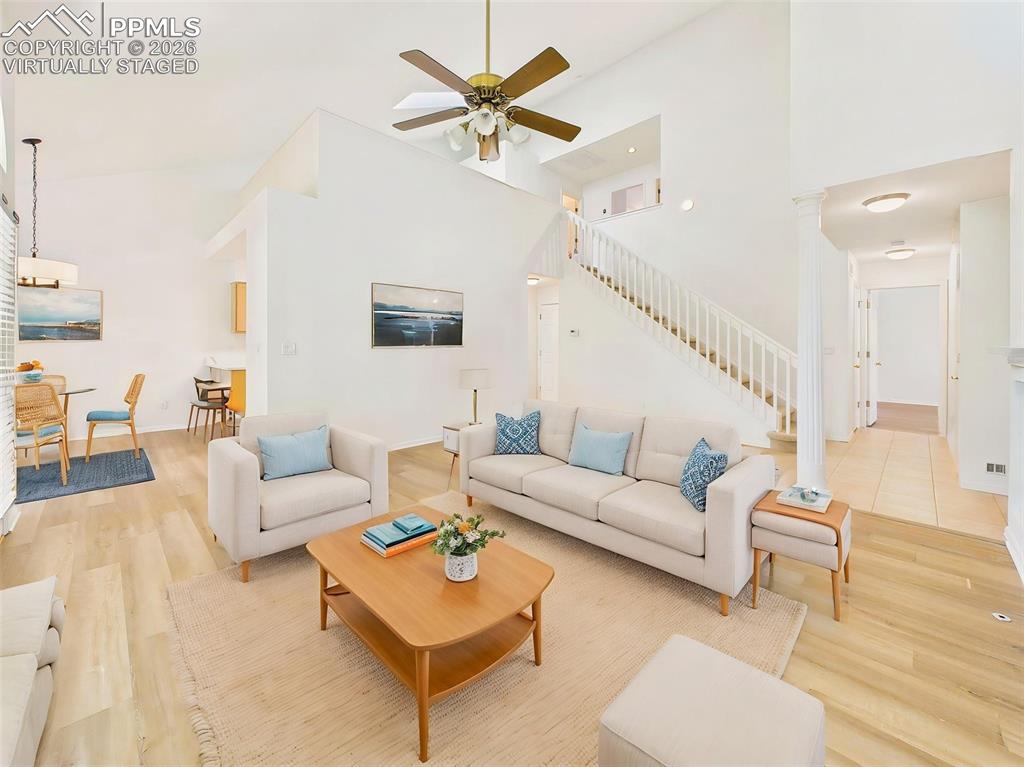 Image 10 of 50: Virtually Staged Bright and inviting living room featuring soaring vaulted 