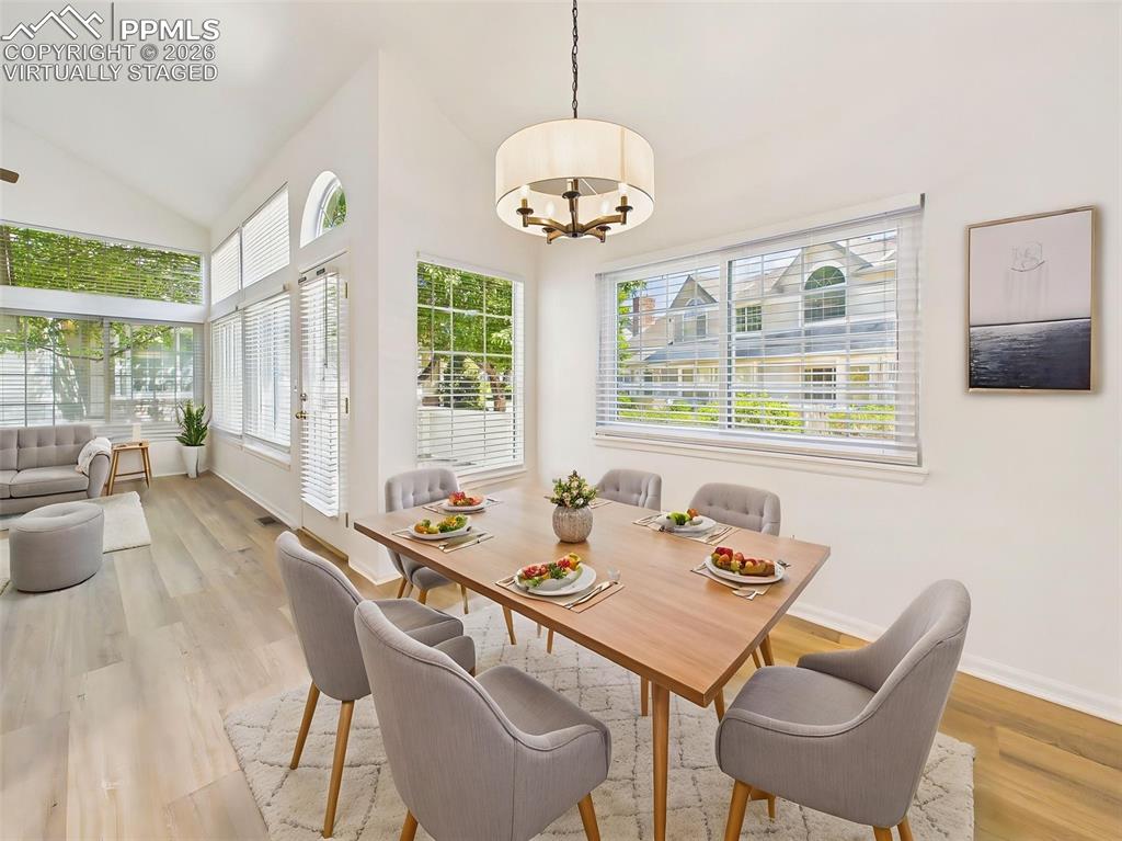Image 12 of 50: Virtually Staged Welcoming dining area with vaulted ceiling and modern ligh