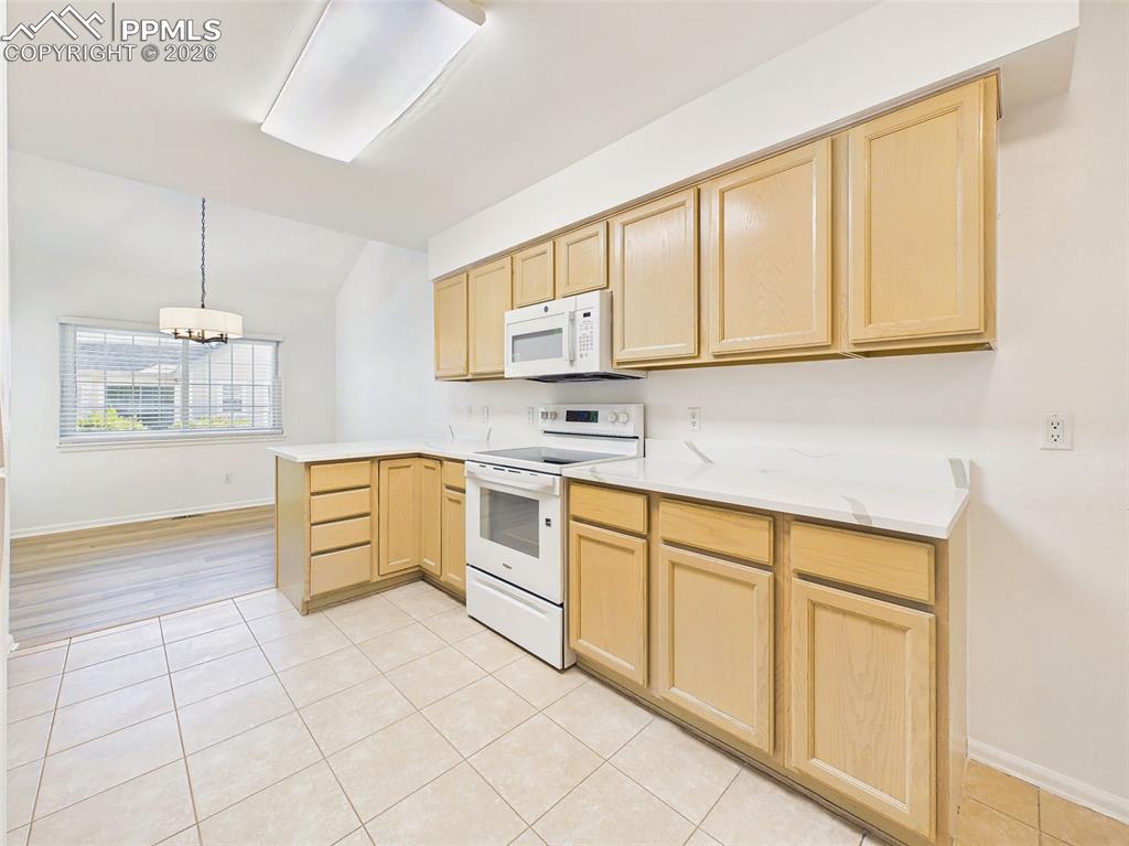 Image 19 of 50: Bright eat-in kitchen with ample cabinetry, new countertops, and space for 