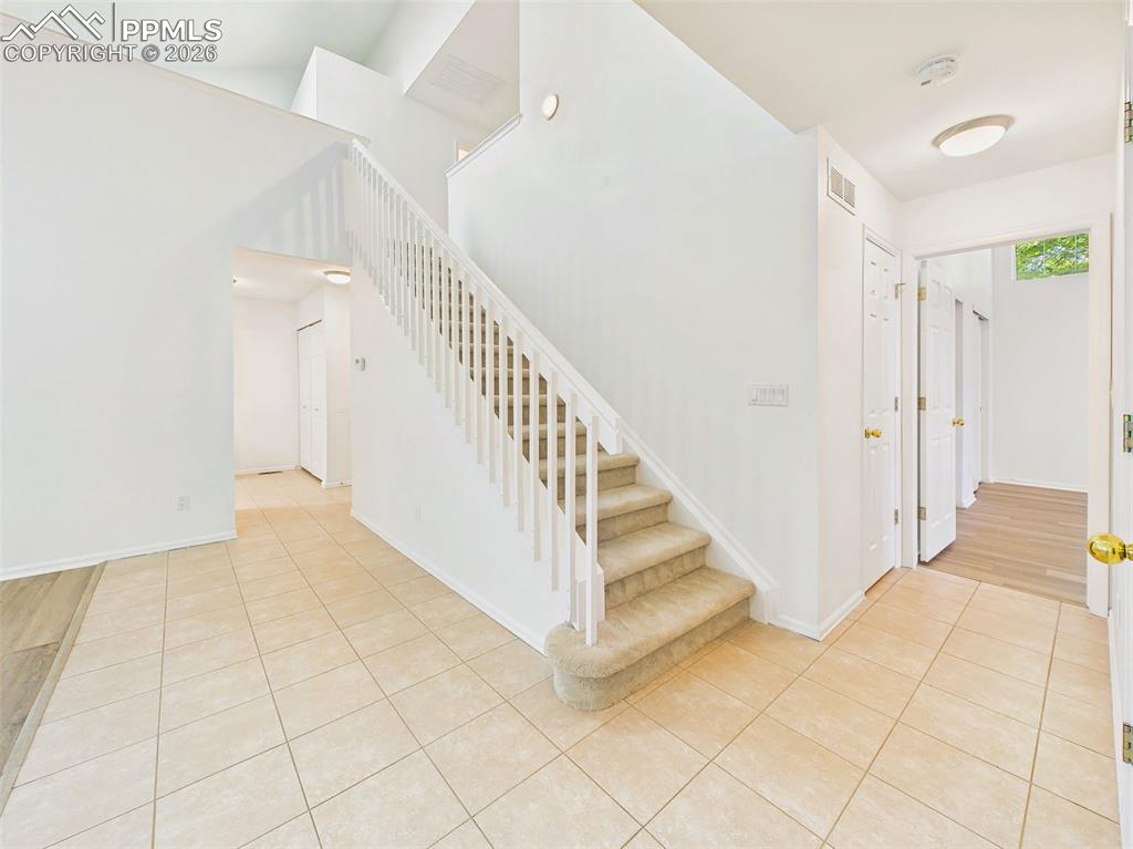 Image 3 of 50: Foyer & Staircase – Welcoming entry with tile flooring, a central staircase