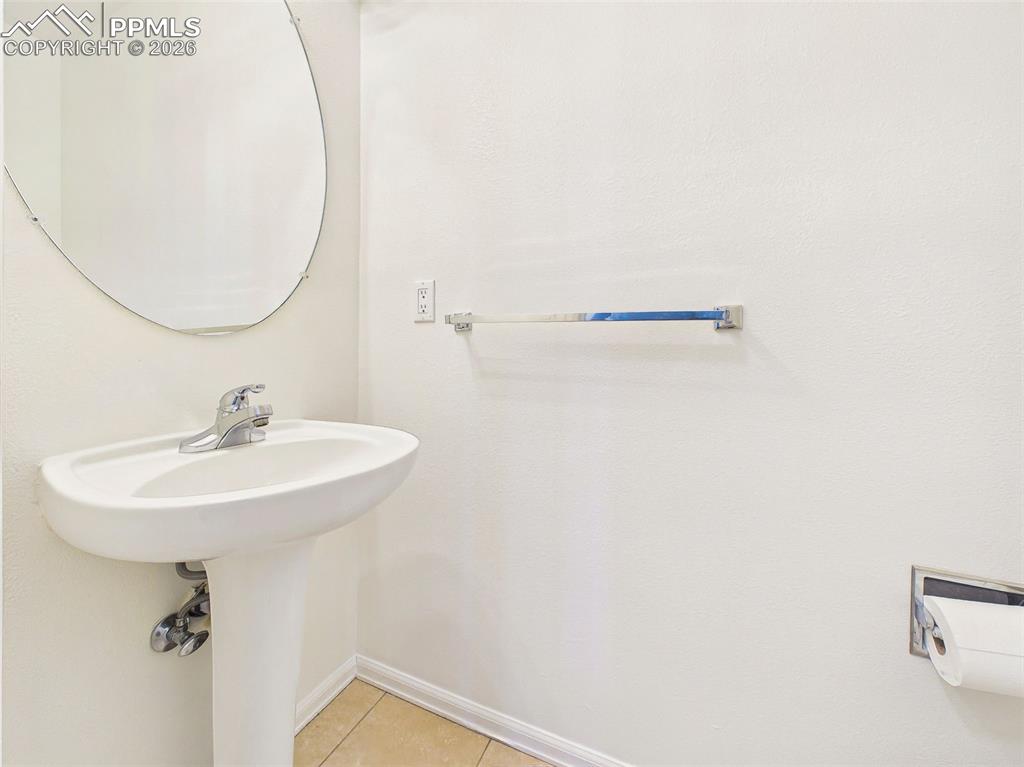 Image 30 of 50: Half Bathroom – Convenient main-level half bath featuring pedestal sink and
