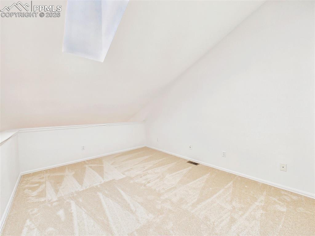Image 32 of 50: Loft (Alternate View) – Bright loft area with sloped ceilings and skylight,
