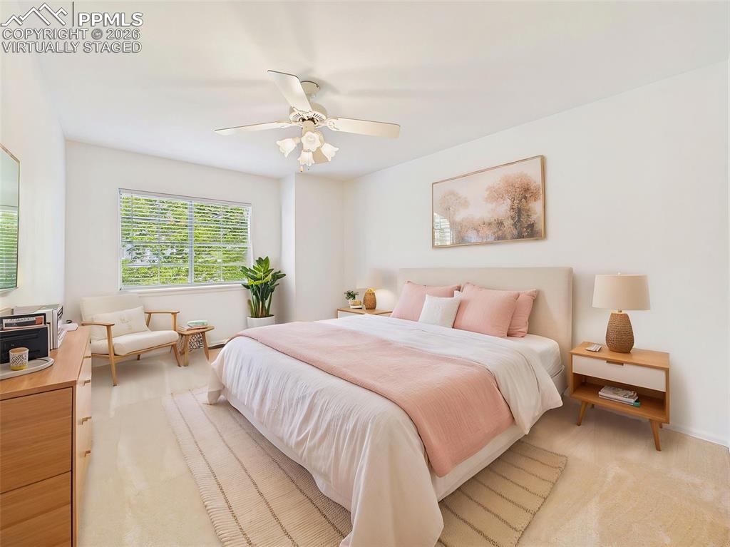 Image 35 of 50: Virtually Staged Well-sized bedroom with large window, ceiling fan, and a b