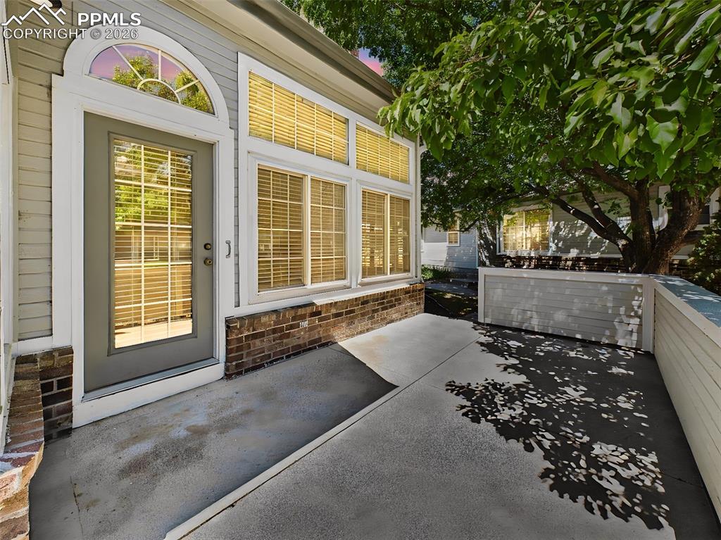 Image 42 of 50: Patio (Alternate View) – Extended patio area with shade from surrounding tr