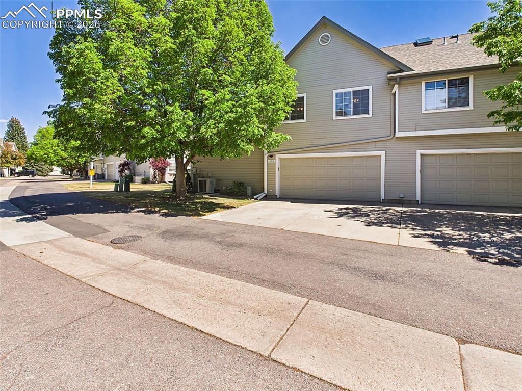 Image 44 of 50: Garage & Exterior – Well-maintained exterior with attached garages and conv