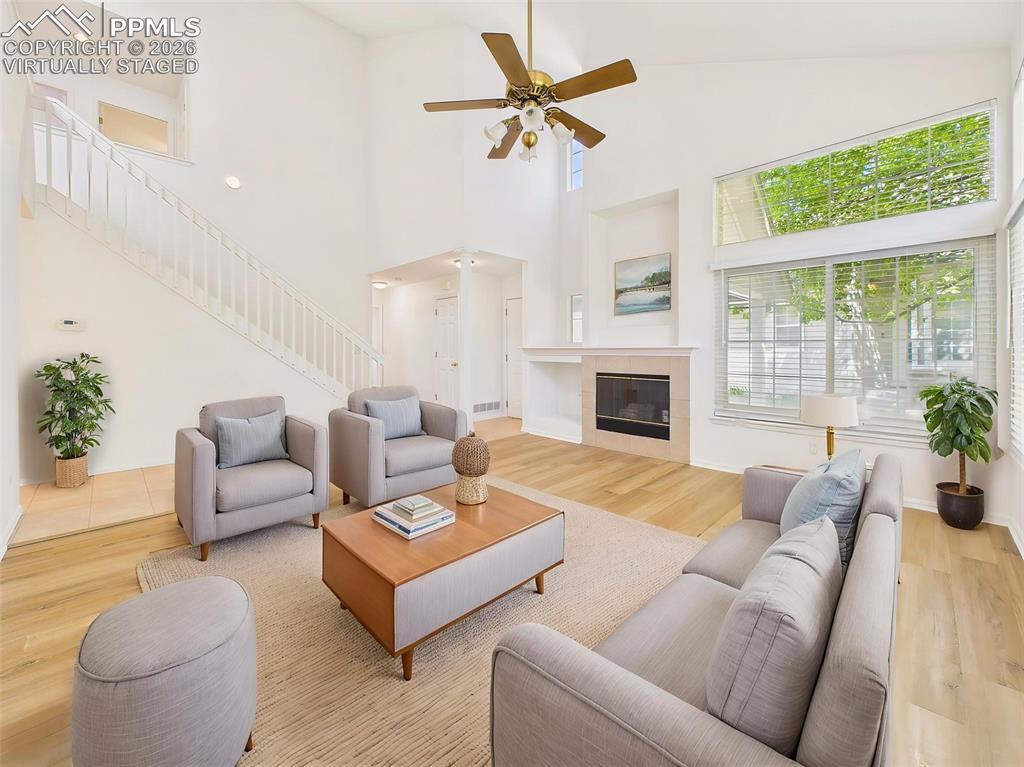 Image 8 of 50: Virtually Staged Sunlit living room centered around a cozy fireplace, with 