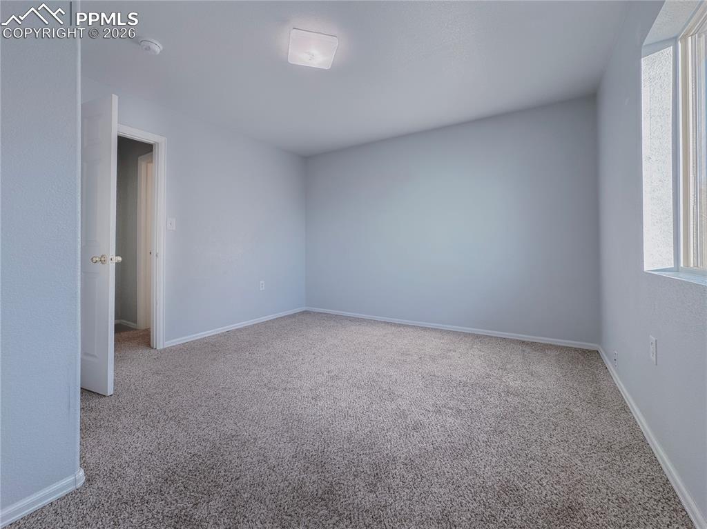 Image 11 of 27: Empty room with light carpet and baseboards