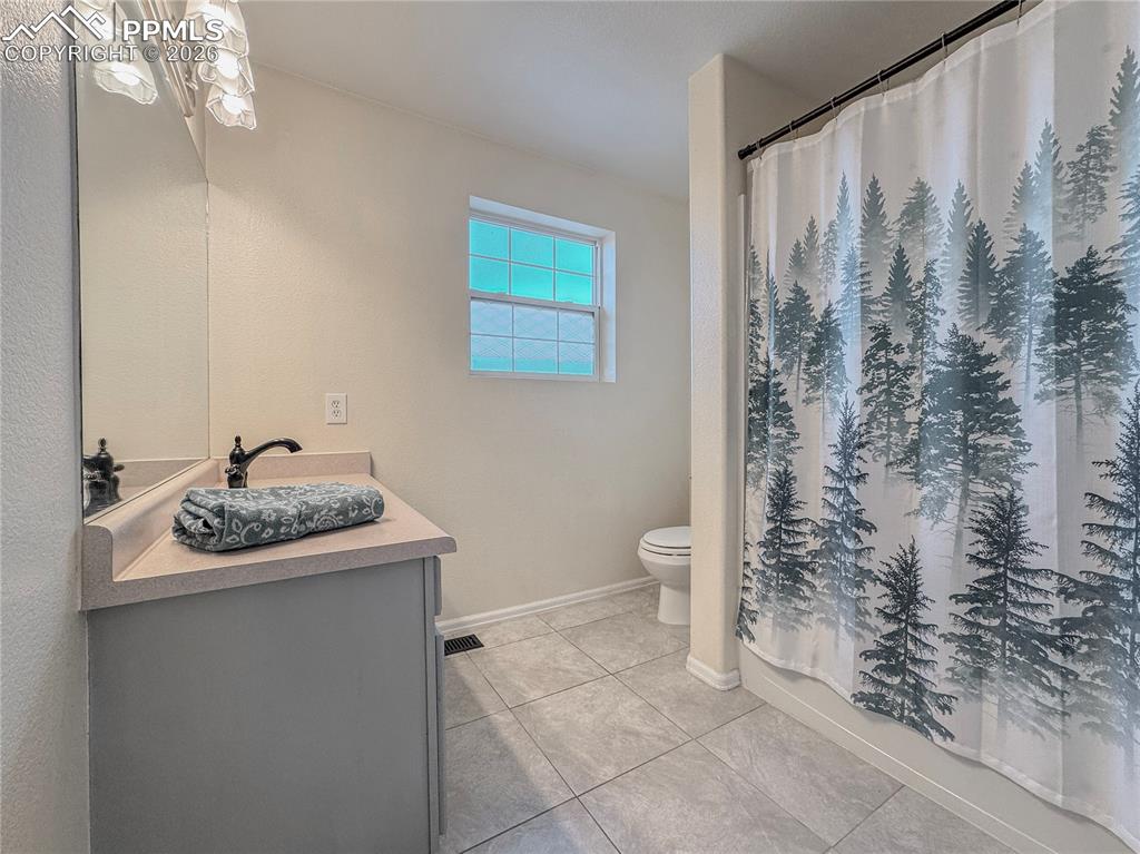 Image 16 of 27: Full bath featuring vanity, shower / bath combo, and light tile patterned f