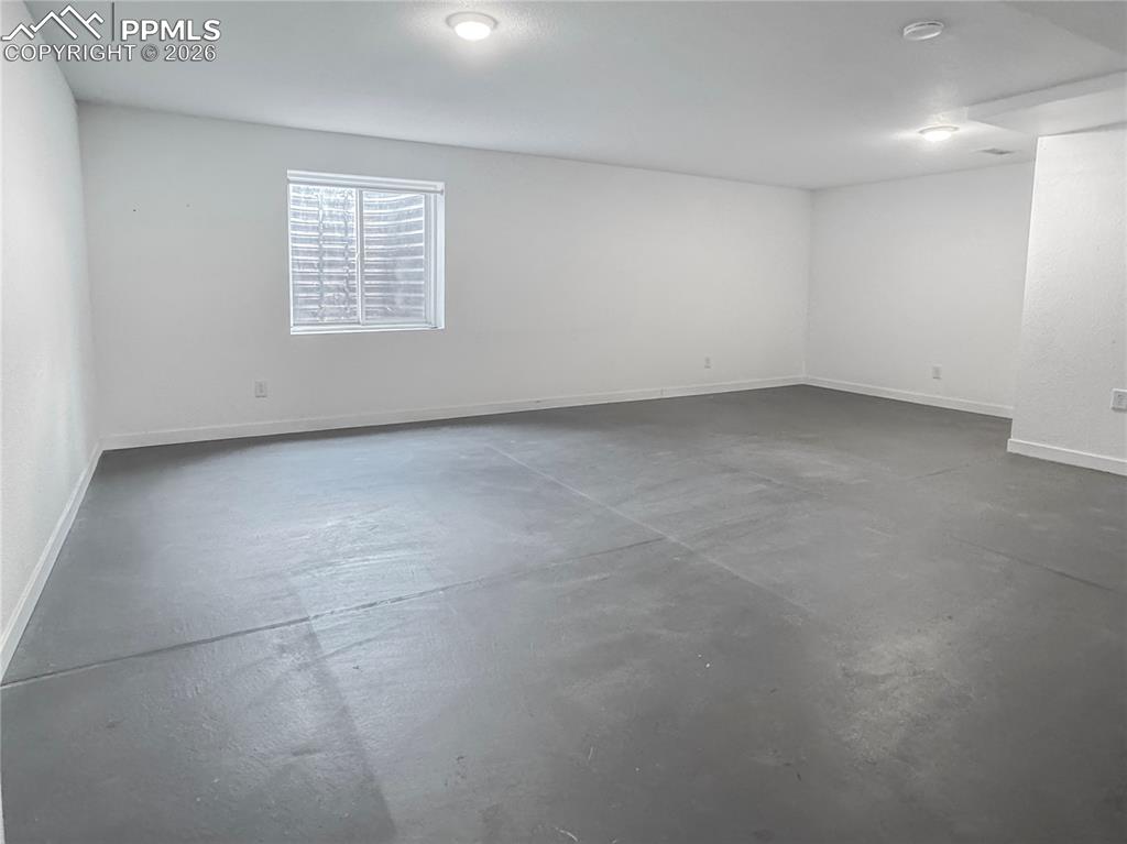 Image 18 of 27: Empty room with baseboards and concrete floors