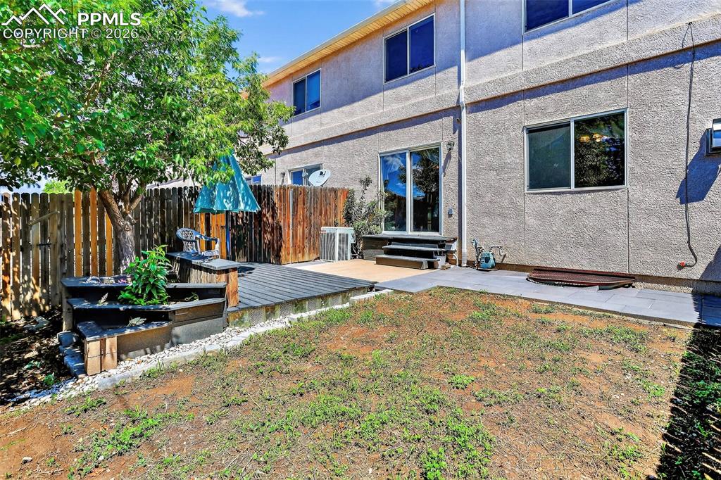 Image 23 of 27: Back of property with a patio, stucco siding, and entry steps