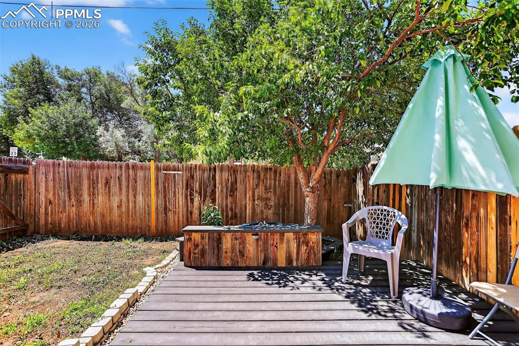 Image 26 of 27: Wooden deck with a fenced backyard