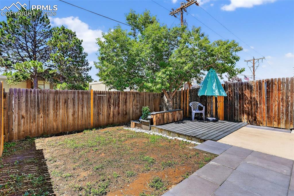 Image 27 of 27: Fenced backyard with a patio area