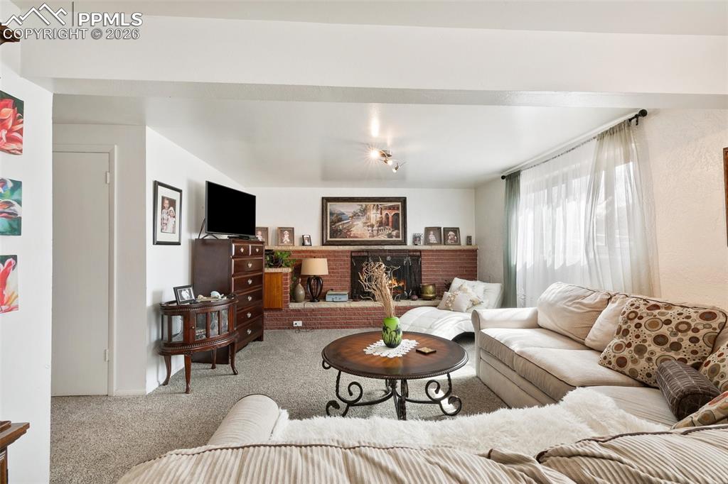Image 21 of 49: Lower level living room with wood burning fireplace