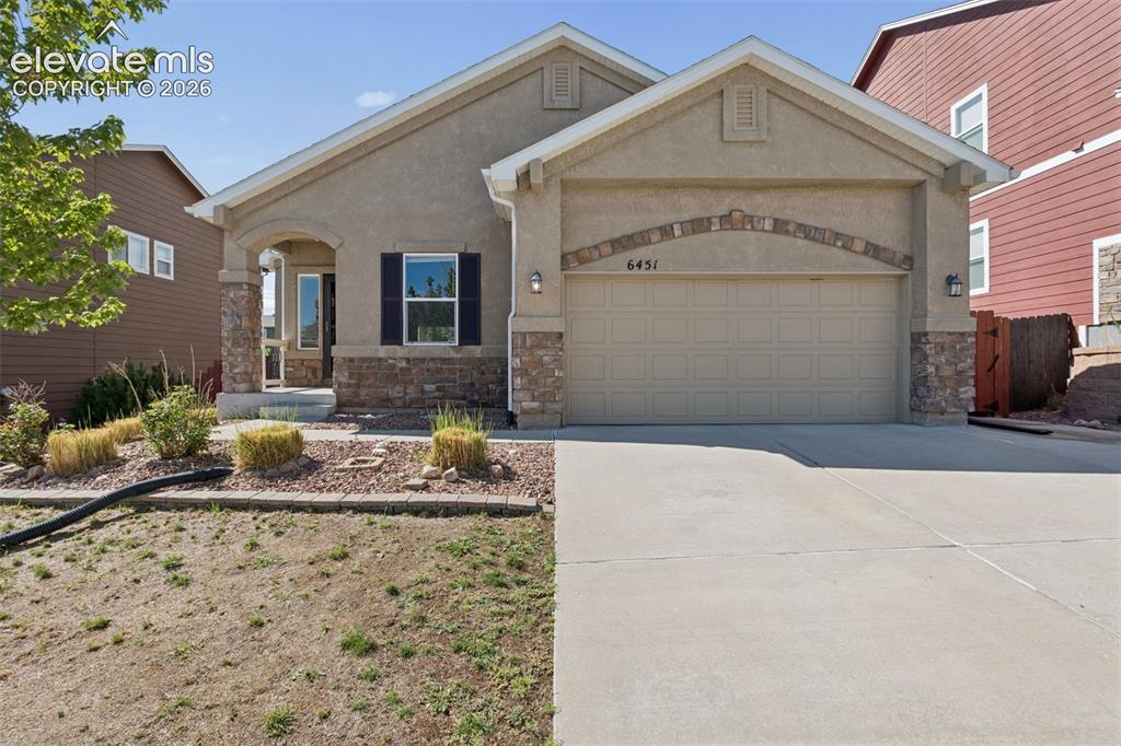 Image 1 of 46: Stucco exterior featuring stone accents, an arched entry, and a two-car gar